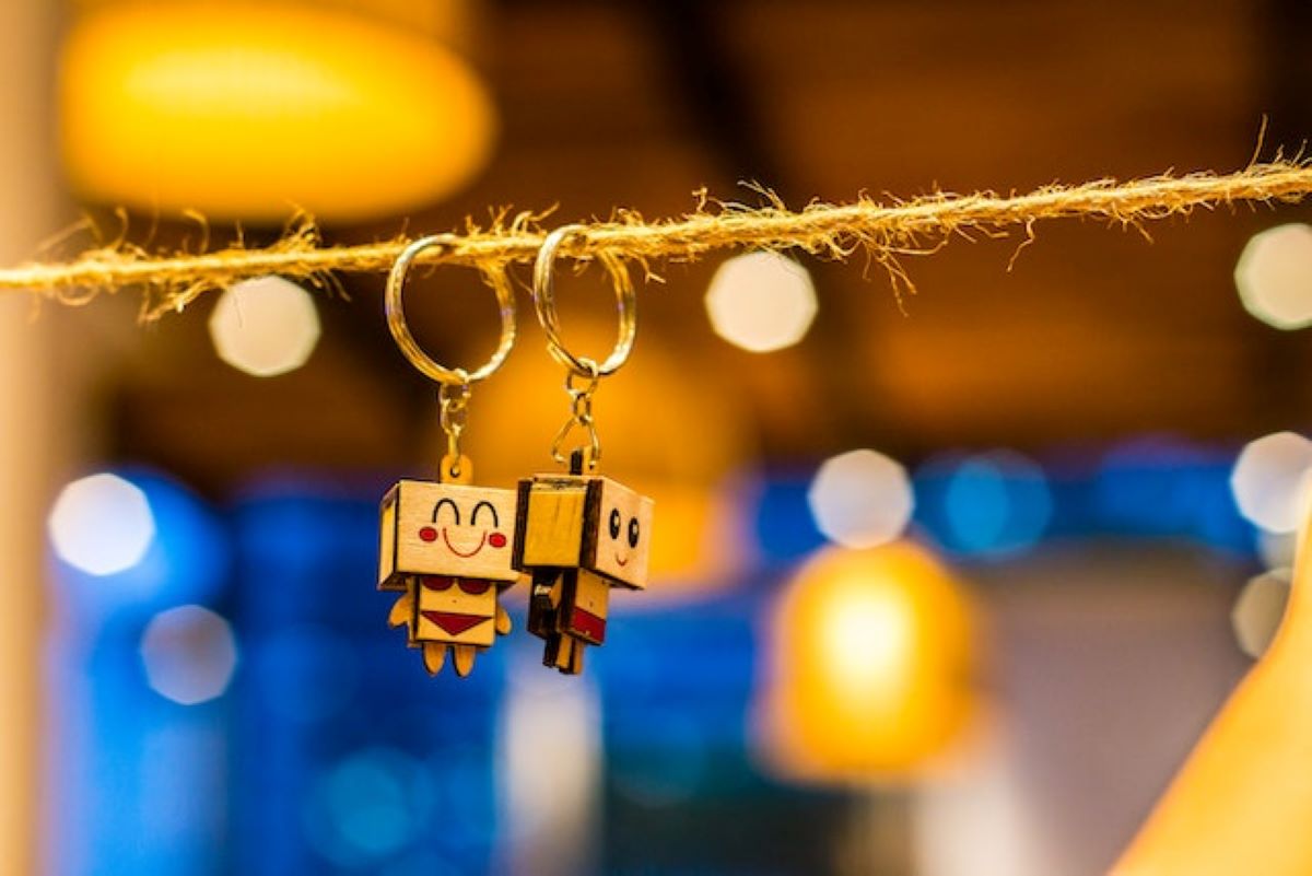 Cute wooden robot keychains hanging on twine with warm bokeh lighting