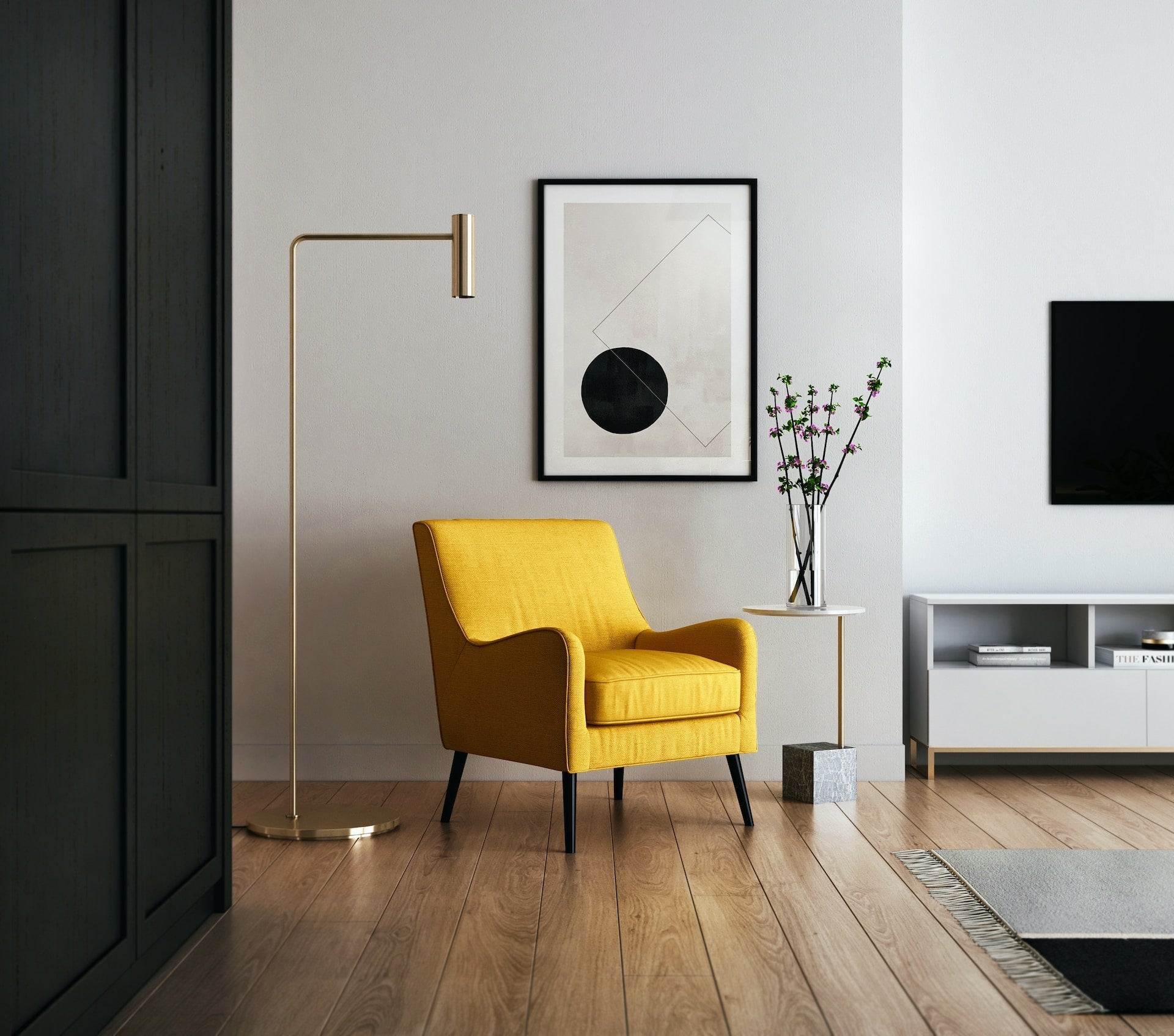 A modern living room featuring a vibrant yellow armchair, gold floor lamp, and abstract art blending contemporary style with bold color accents