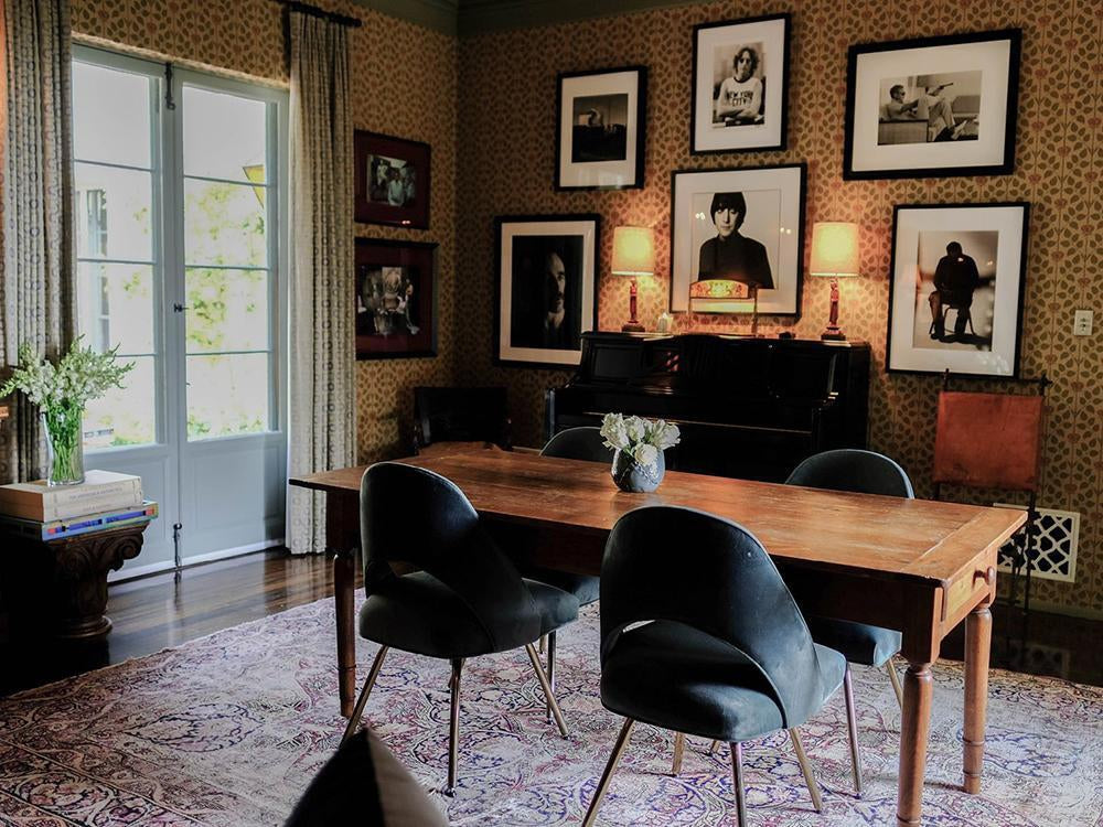 How to Buy Art for Your Home: The 7 Essentials-Brush Point Studio (Warm dining room with vintage wallpaper, framed black-and-white portraits, and a wooden table under soft lamp light.)